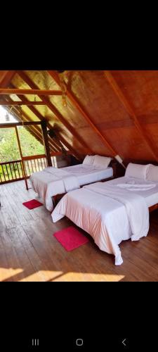 a group of three beds sitting in a room at Ohiya Our Time Kabana in Ohiya
