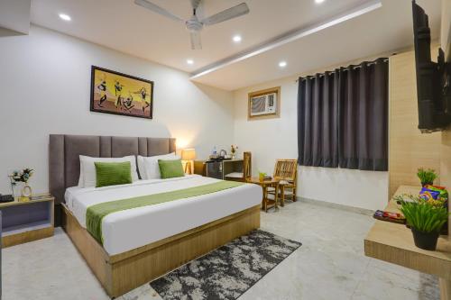a bedroom with a large bed and a desk at Castle Grand Dwarka in New Delhi