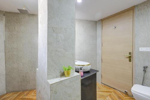 a bathroom with a toilet and a sink and a door at Castle Grand Dwarka in New Delhi