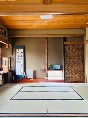 a living room with a wooden ceiling at ゲストハウスさちさんち in Wagō