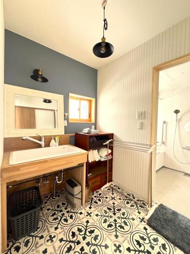 a bathroom with a sink and a shower at ゲストハウスさちさんち in Wagō