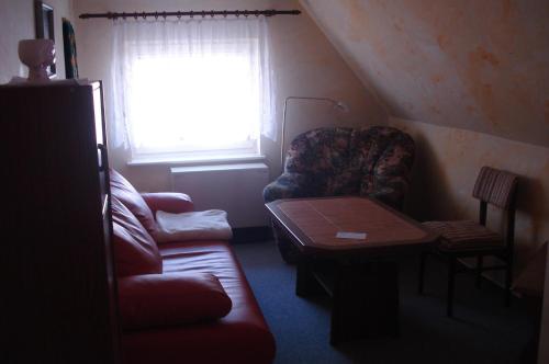 ein Wohnzimmer mit einem Sofa und einem Tisch in der Unterkunft Apartment Neuendorf - Hiddensee 1 in Neuendorf