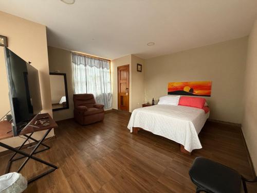 a bedroom with a bed and a flat screen tv at DEPARTAMENTO ENCANTO AMAZÓNICO Macas in Macas