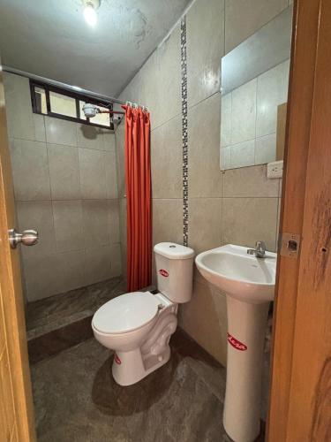 a bathroom with a toilet and a sink at DEPARTAMENTO ENCANTO AMAZÓNICO Macas in Macas