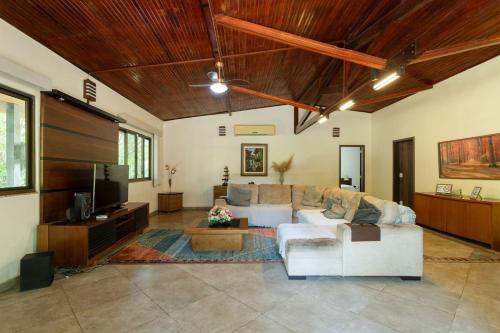 a living room with a couch and a tv at Chacara Morada do Sol com Piscina e Churrasqueira in Sepetiba
