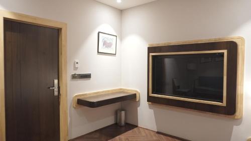 a bathroom with a large television and a door at The LEGACY HOTEL JAMSHEDPUR in Jamshedpur