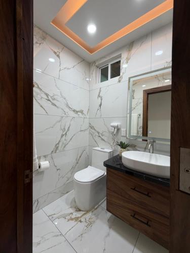 a bathroom with a sink toilet and a mirror at Monbelt Luxury Apartment with Rooftop Jacuzzi in Puerto Vallarta