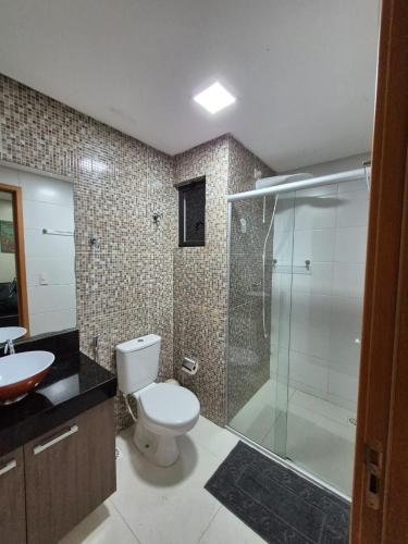a bathroom with a toilet and a glass shower at Flat Macambira Home Service in Campina Grande