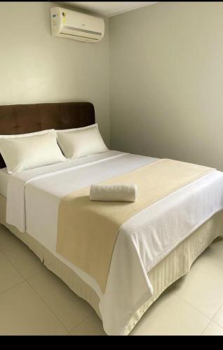 a large white bed with a pillow on top of it at Flat Macambira Home Service in Campina Grande