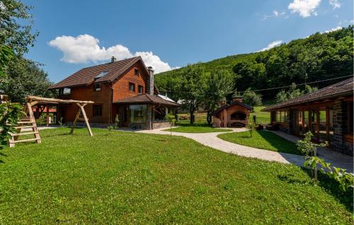a house with a grass yard next to a building at Pet Friendly Home In Debelo Brdo With Sauna in Debelo Brdo