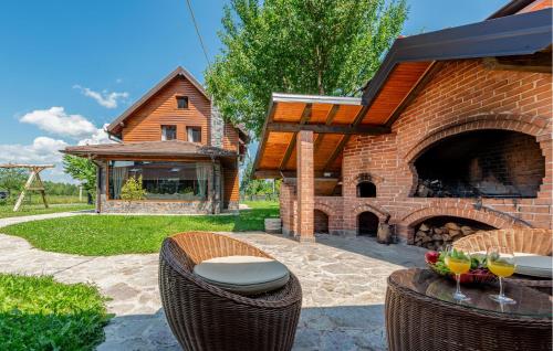 a patio with a brick fireplace with two glasses of wine at Pet Friendly Home In Debelo Brdo With Sauna in Debelo Brdo