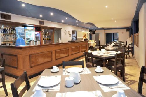 a restaurant with tables and chairs and a bar at Hotel del Principado Durango in Durango