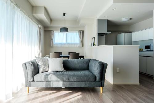a living room with a couch and a kitchen at Formosa Hills in Kumamoto