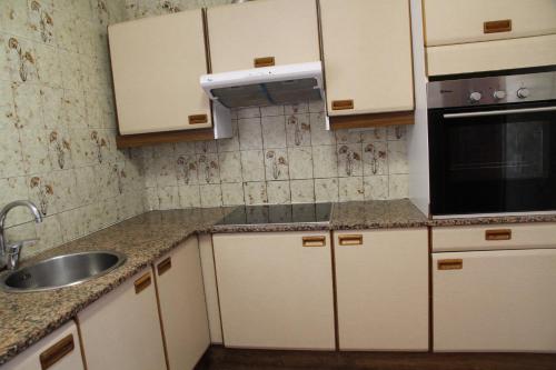 a kitchen with white cabinets and a sink at Maresto Calle Mar in Salou