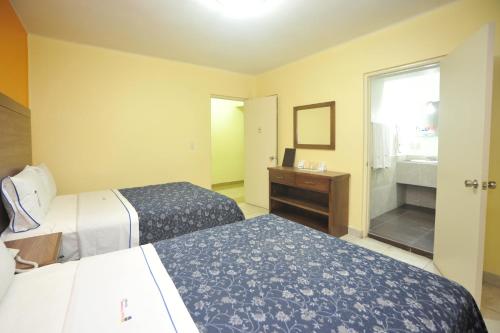 a hotel room with two beds and a window at Hotel del Principado Durango in Durango