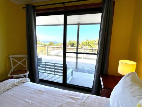 a bedroom with a bed and a large glass window at Ocean Whisper in Island Beach