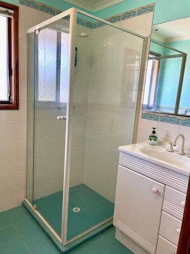 a bathroom with a shower and a sink at Ocean Whisper in Island Beach