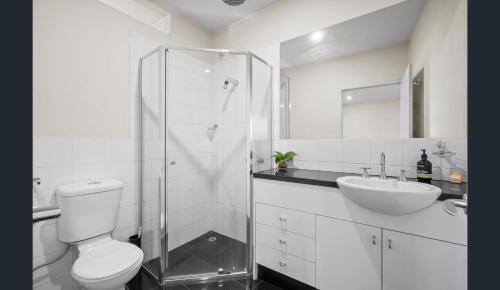 a white bathroom with a toilet and a sink at Convenience & Luxury Apartment in Melbourne