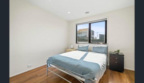 a bedroom with a bed and a window at Convenience & Luxury Apartment in Melbourne