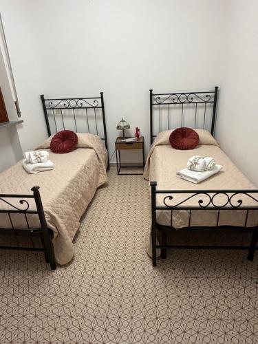 two beds with red pillows in a bedroom at La Terrazza al tramonto CITRA in Lerici