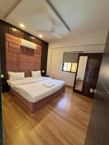 a bedroom with a large bed and a wooden floor at Villa 37 in Dhamni