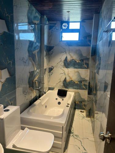 a bathroom with a toilet and a sink and a tub at Villa 37 in Dhamni
