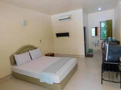 a bedroom with a bed and a television in it at 057 รีสอร์ท in Ban Huai To