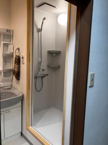 a shower in a bathroom with a glass door at Wonder House in Shingū