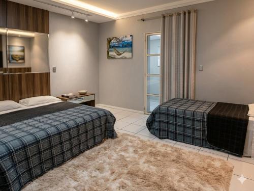 a bedroom with two beds and a window at Londrina Hostel Il in Londrina