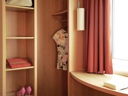 a room with a book shelf and a window at ibis Swansea in Swansea