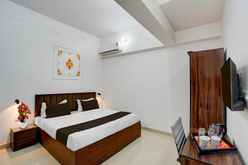 a hotel room with a bed and a tv at Super OYO Collection O Prayag Railway Junction in Colonelganj
