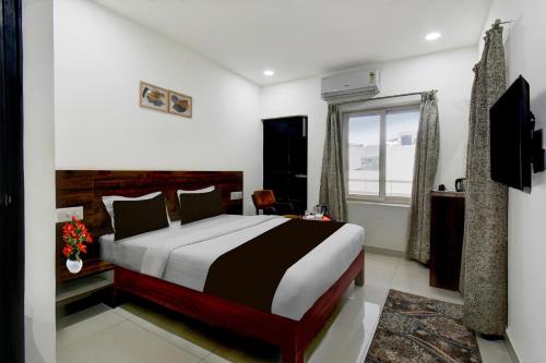 a bedroom with a large bed and a window at Super Hotel O Mysore Zoological Park Formerly Queens Comfort in Mysore