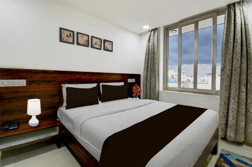 a bedroom with a large bed and a window at Super Hotel O Mysore Zoological Park Formerly Queens Comfort in Mysore