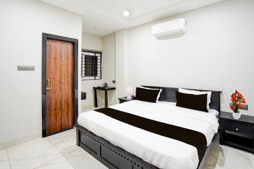 a bedroom with a large bed and a wooden door at Super Townhouse Rajendra Nagar Main Road in Indore