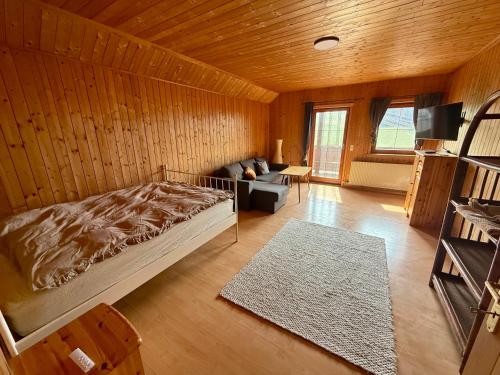 a bedroom with a bed and a couch in a room at Das Holzhaus in Haidershofen