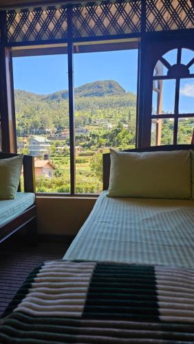 a bedroom with a bed and a large window at Aurora Residence Nuwara Eliya in Nuwara Eliya
