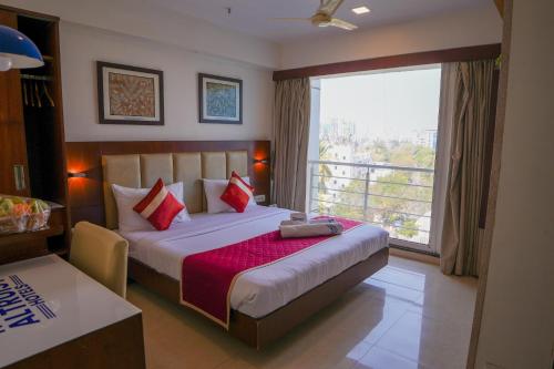 a bedroom with a bed with a large window at The Altruist Andheri Hotel in Mumbai