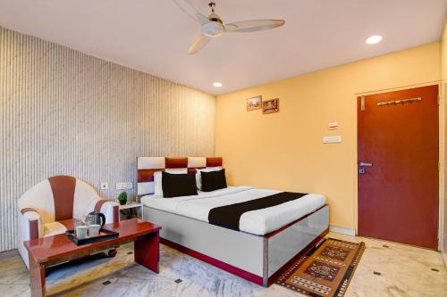 a bedroom with a bed and a table and a chair at Super Collection O Rajarhat Formerly Redstone in Kolkata
