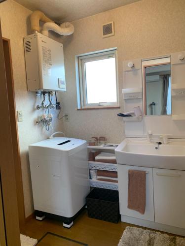 ein Badezimmer mit Waschbecken und Spiegel in der Unterkunft Bon Clair in Sunagawa