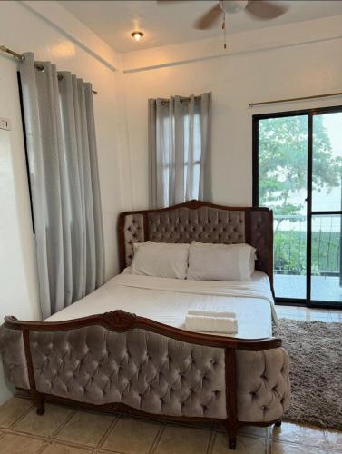 a large bed in a room with a large window at White beach Villa in Panglao Island