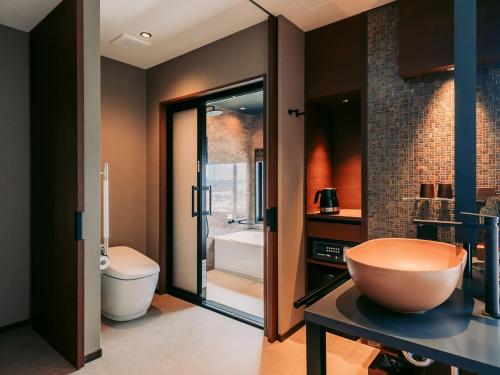 a bathroom with a toilet and a large bowl on a table at Tanegashima Araki Hotel in Nishinoomote