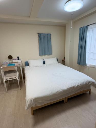 a bedroom with a large white bed and a desk at ToyamaHouse2-203 in Tokyo