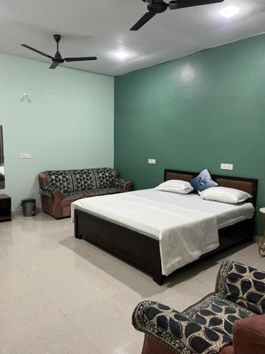 a bedroom with a large bed and a couch at Shyam Hotel & Janmasa in Rewa
