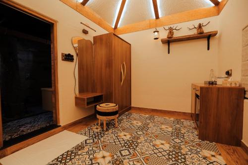 a room with a table and a stool on a rug at HoneyStone Resort in Sultan Bathery