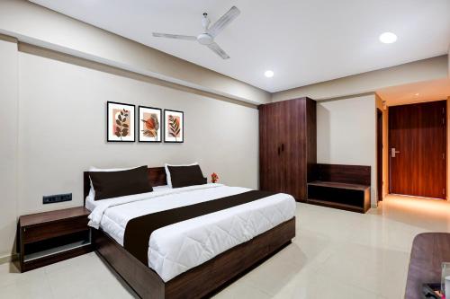 a bedroom with a large bed and a ceiling fan at Townhouse GIDC Ankleshwar Formerly Studio 60 in Kosamri