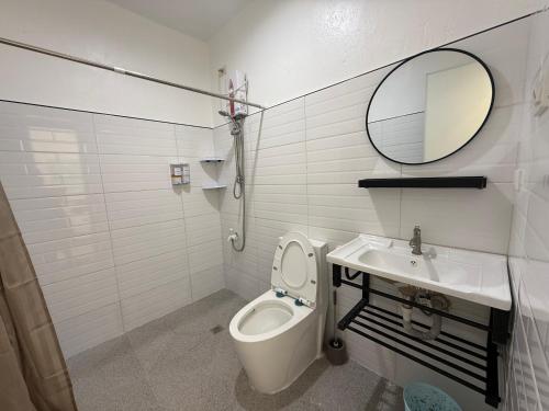 a bathroom with a toilet and a sink and a mirror at Ivorys Guesthouse in Panglao Island