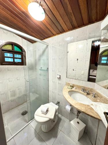 a bathroom with a toilet and a sink and a shower at Pousada do Sino - 2 min do Capivari in Campos do Jordão