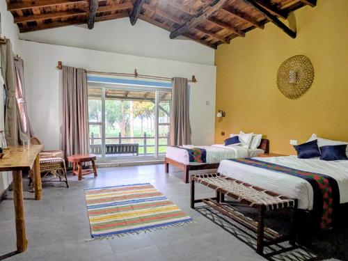 a large room with two beds and a window at Bardiya Nature Lodge in Belā