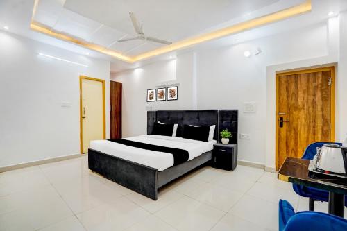 a bedroom with a bed and a desk and chairs at Hotel O Jaimantri Palace in Bihār Sharīf