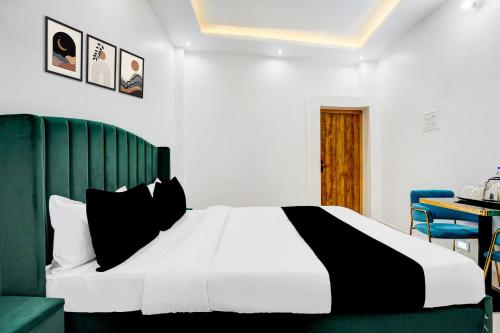 a bedroom with a white bed with black pillows at Hotel O Jaimantri Palace in Bihār Sharīf
